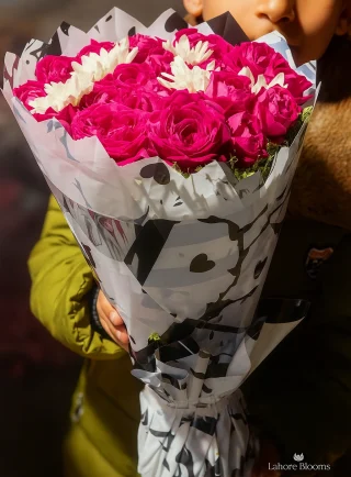 Romantic pink rose bouquet with white flowers in heart wrapping held by child – Lahore Blooms