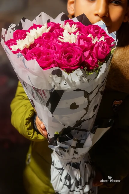 Romantic pink rose bouquet with white flowers in heart wrapping held by child – Lahore Blooms