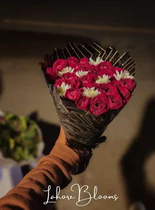 Compact pink rose bouquet with white flowers in black wrapping – Lahore Blooms