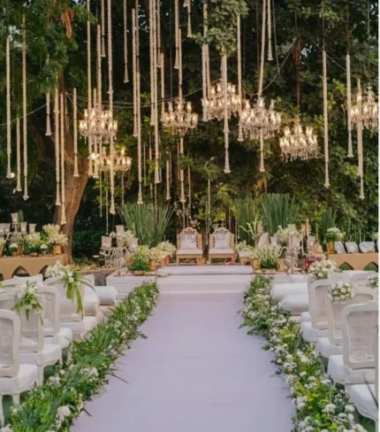 Luxury outdoor barat and walima stage decoration with chandelier canopy, grand aisle floral setup and forest theme lighting in Lahore