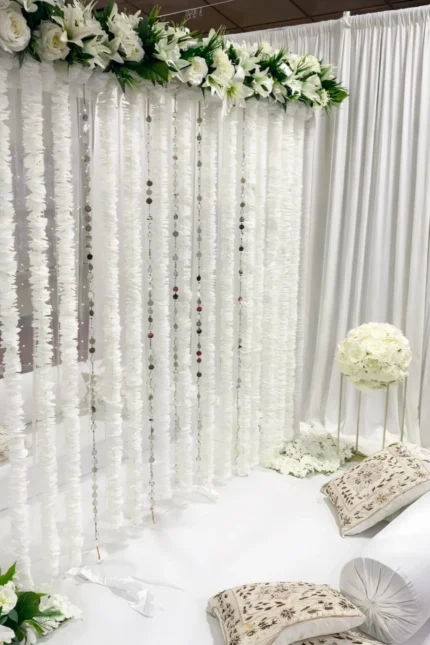 White curtain nikah backdrop with hanging floral strings and top flower border in Lahore