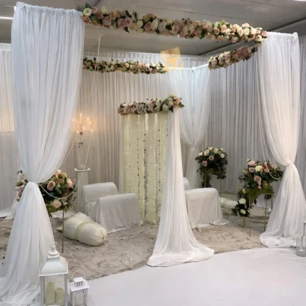 Elegant white floral nikah stage decoration setup with draped backdrop and pastel canopy in Lahore