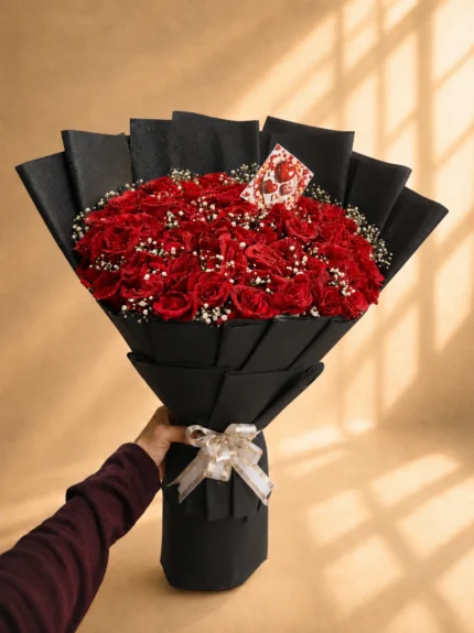 A statement bouquet dressed in deep red. The Rouge brings together lush red roses and soft baby’s breath in a grand hand-tied style, finished with premium wrapping in black, white, pink, or a custom shade on request.