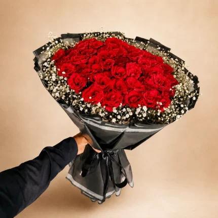 Velvet Rouge red rose bouquet with white baby’s breath and black wrapping in Lahore