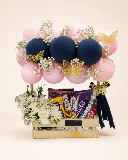 Golden Flutter birthday gift basket with chocolates, white flowers, pink and navy balloons in Lahore