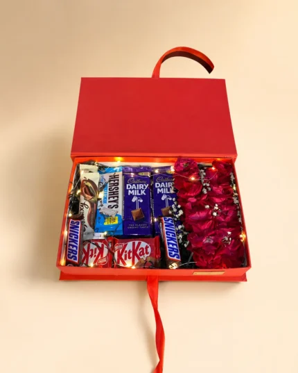 Red birthday chocolate gift box with Dairy Milk, KitKat, Snickers, Hershey's, red roses and warm fairy lights