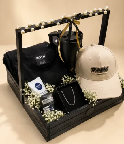 Black wooden birthday hamper for him with black shirt, beige cap, tumbler, men's grooming products, chain accessory and baby's breath flowers
