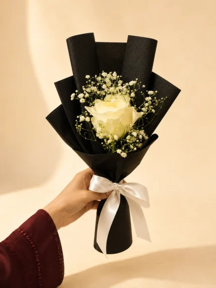 Pearl Note single white rose bouquet with baby’s breath in black wrapping and white ribbon