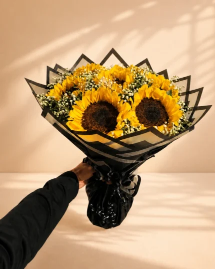 Sunlit Noir fresh sunflower bouquet with white baby’s breath and black-and-gold wrapping