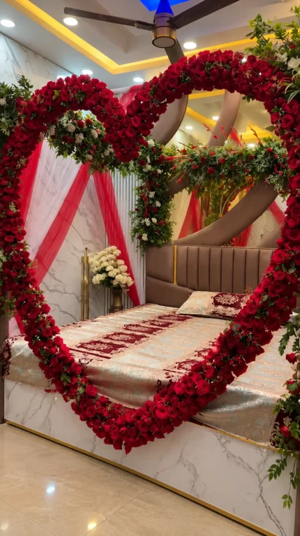A prominent heart outline and bed framing made with fresh imported red roses in a Lahore bridal bedroom