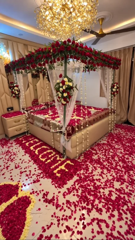 Fresh imported roses in a bridal canopy, paired with fresh floral details and a visible LOVE petal design on the bed in a Lahore bridal bedroom