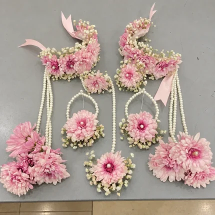 Blush pink chrysanthemum-style flowers, white filler flowers and pearl-style strands, wrist kalire with clustered floral drops.