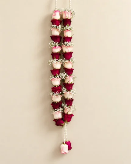 Alternating pink and red roses separated by small white filler flowers, with a hanging floral drop.