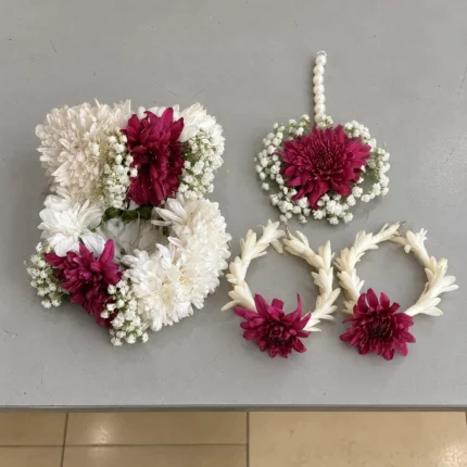 Burgundy and white blooms with small white filler flowers, matching wrist pieces, earrings and forehead ornament.
