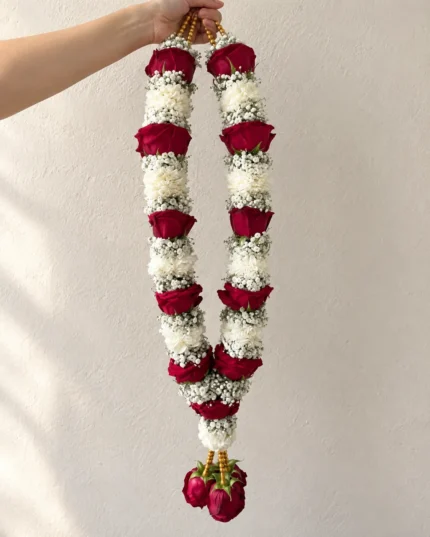 Alternating dense white floral sections and red rose bands, finished with hanging red rose buds.