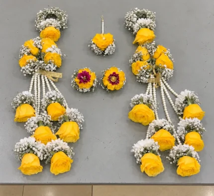 Yellow roses with white filler flowers, cascading pearl-style strands and rose drops on the wrist kalire.