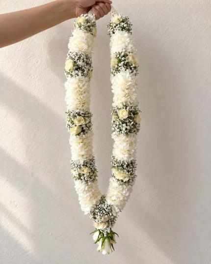 Dense white floral sections separated by small white filler-flower bands, finished with a white floral drop.