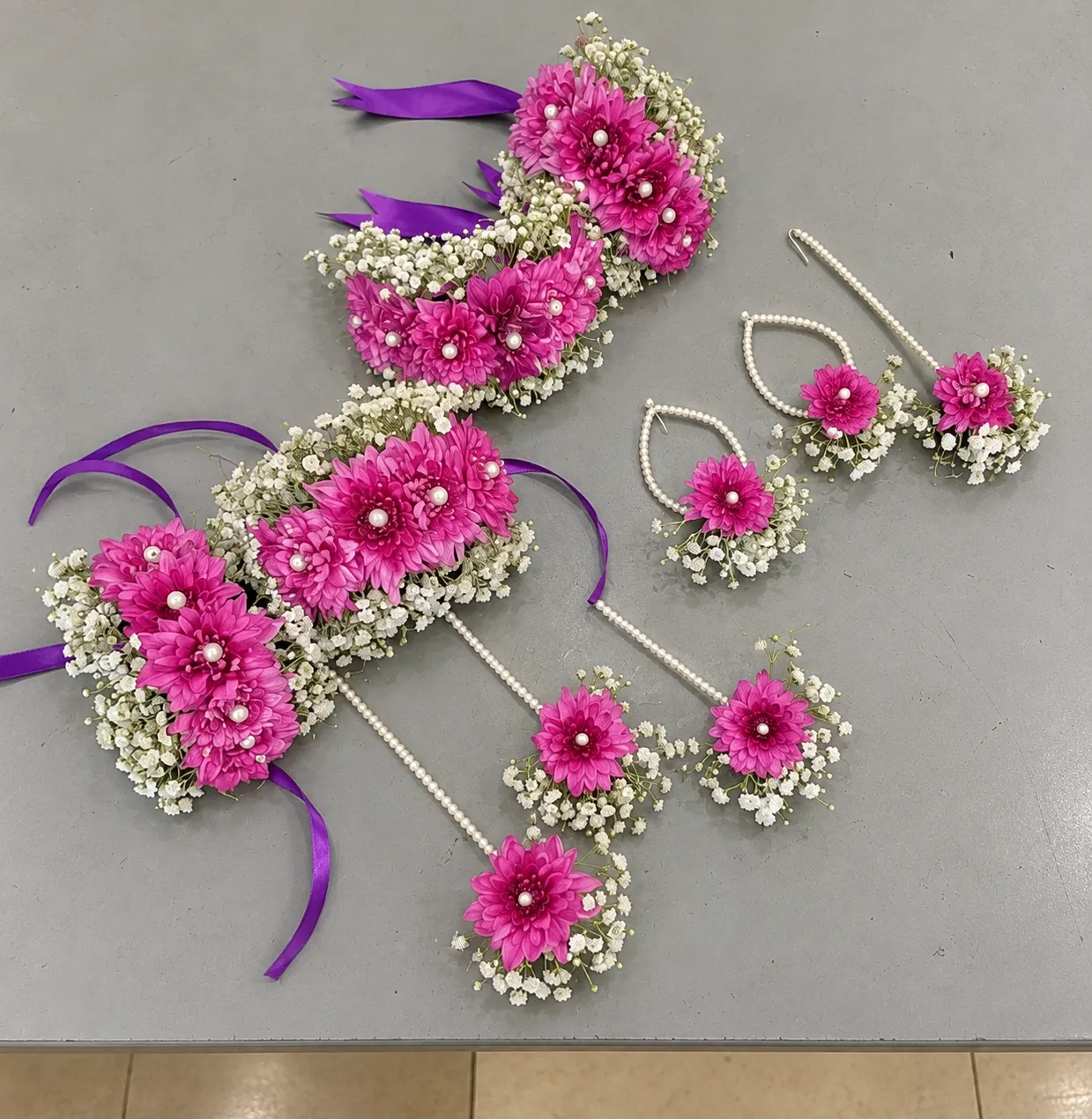 Magenta Bloom Floral Jewellery Set Magenta flowers with white filler flowers, pearl-style centres and purple ribbon ties.