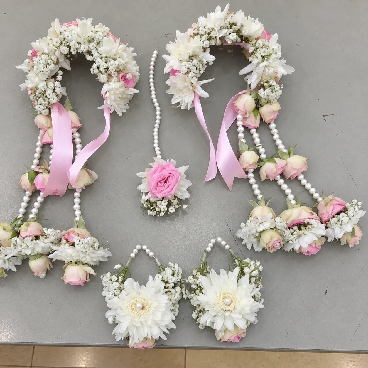 Pink Blossom Floral Crown Jewellery Set White flowers and pink rose accents with pearl-style strands, coordinated floral crown, wrist pieces, earrings and forehead ornament.