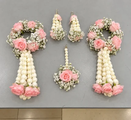 Pink roses with white buds and filler flowers, long white floral strands finish the two wrist kalire.