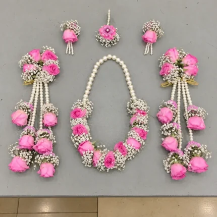 Pink roses and white filler flowers with a pearl-style necklace, long rose-drop kalire and matching ornaments.