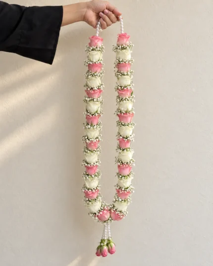 Pink roses alternating with ivory floral sections and white filler flowers, with hanging pink rose buds.