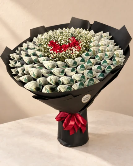 A wide arrangement of curled notes surrounding a red rose heart and white filler flowers.