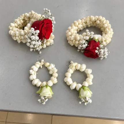 White-bud bangles accented with red roses and white filler flowers, plus matching white-bud earrings.
