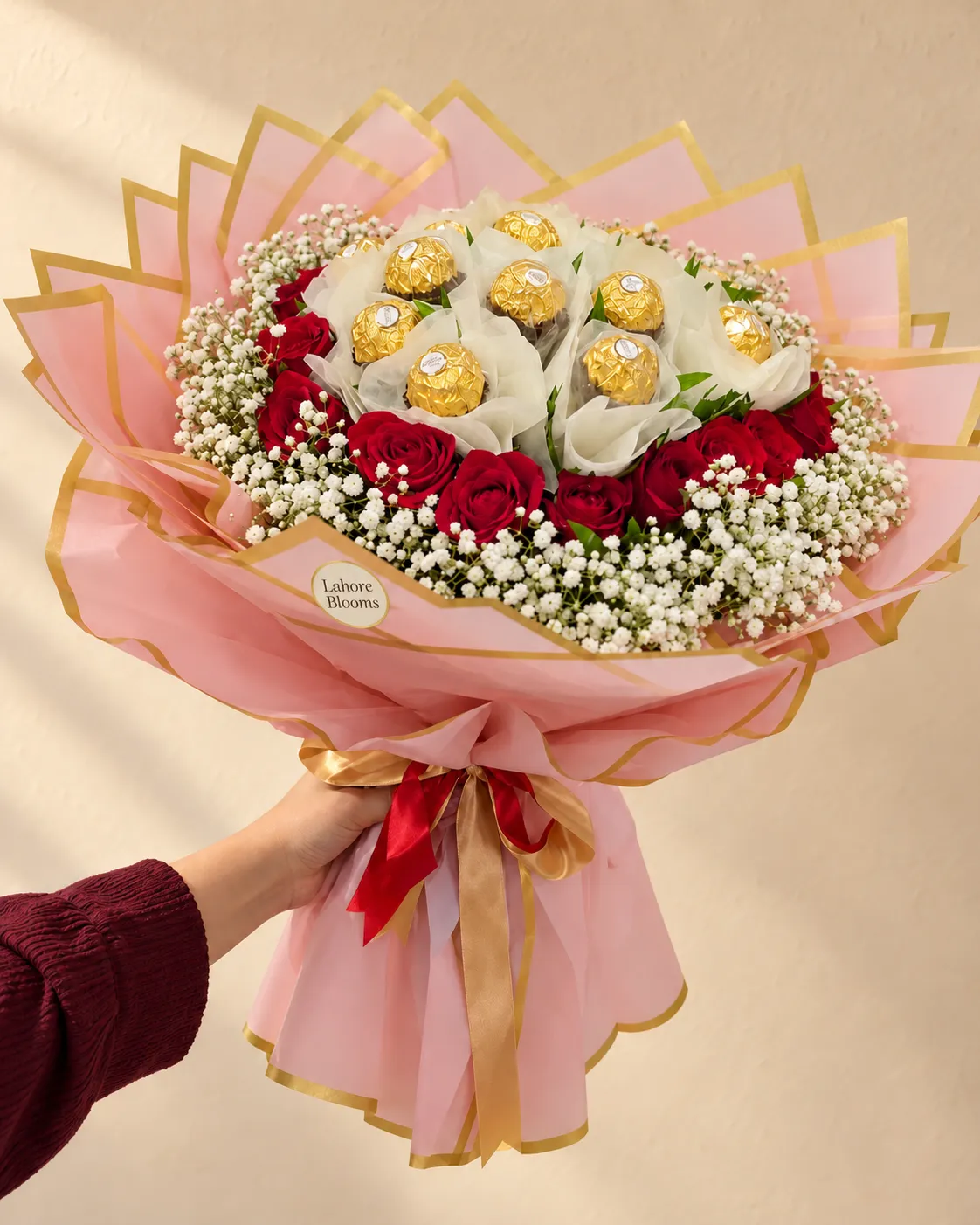 Rose Heart Gold Chocolate Bouquet A red rose heart surrounding gold-wrapped chocolates, with white filler flowers and pink wrapping.