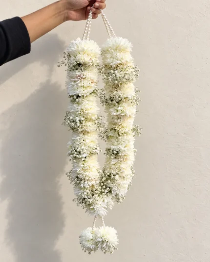 White floral sections with small white filler-flower bands, pearl-style top cords and a white flower tassel.