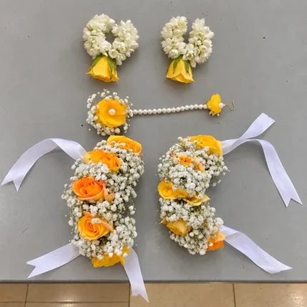 Yellow roses, white filler flowers and pearl-style detailing, with white-bud and yellow-rose earrings.